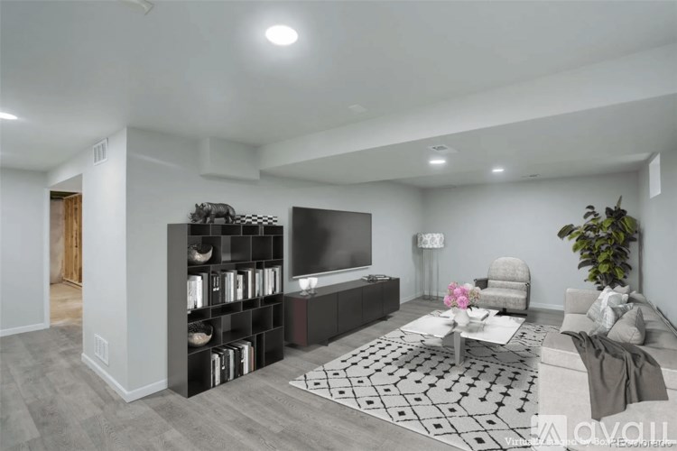 A living room with a grey sofa, a coffee table, and a bookshelf.