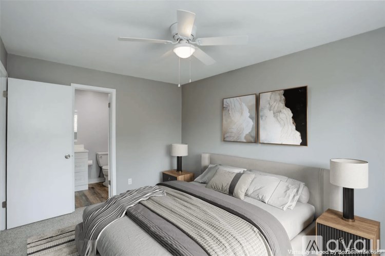 A bedroom with a bed, nightstands, and a ceiling fan.