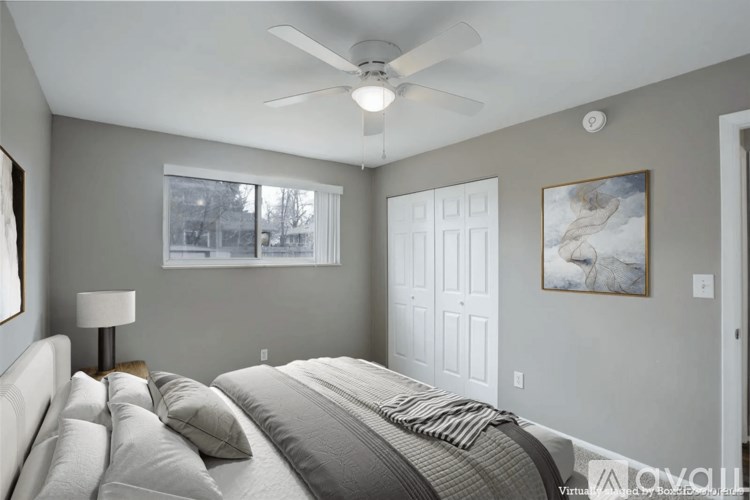 A bedroom with a large bed and a ceiling fan.