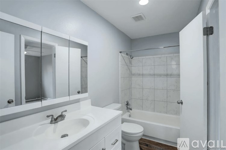 A bathroom with a white sink, mirror, and toilet.