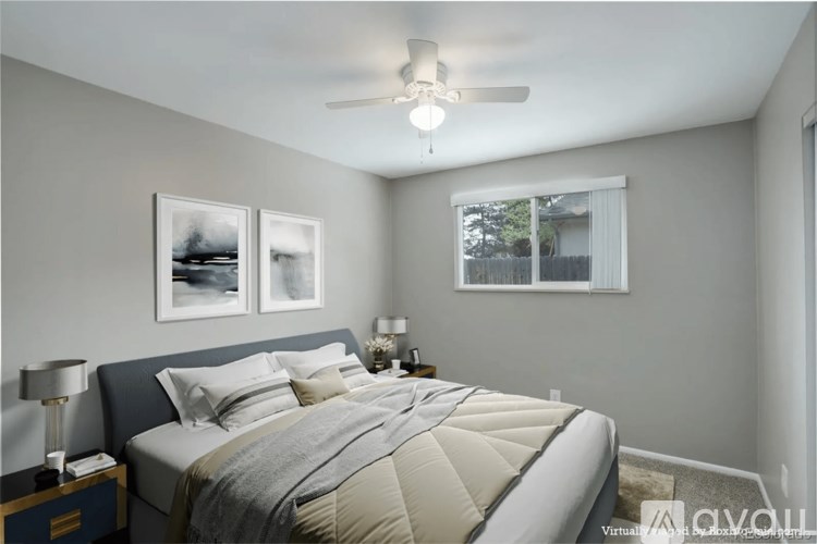 A bedroom with a large bed and two pictures on the wall.