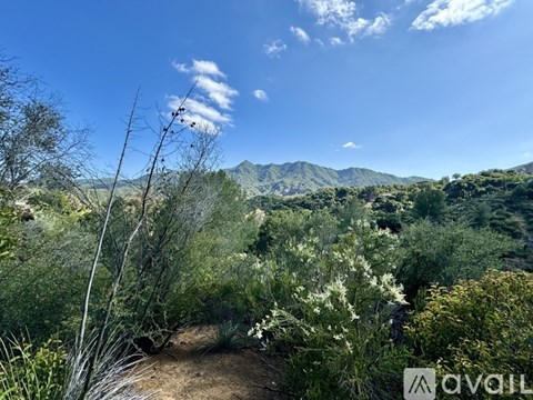 A landscape image of a mountainous area with a clear blue sky.