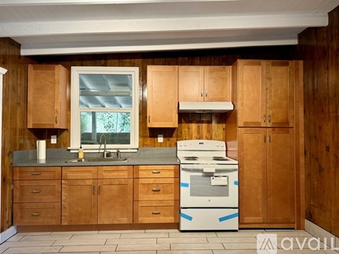 A kitchen with wooden cabinets and a white dishwasher.
