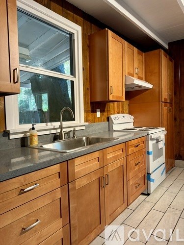 A kitchen with wooden cabinets and a white dishwasher.