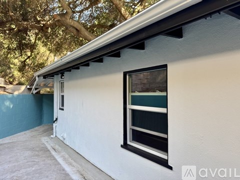 A house with a window and a tree in the background.
