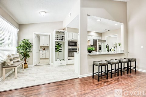 A kitchen with white cabinets and a wooden floor.