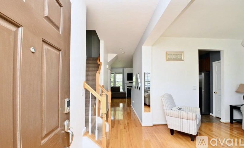 A living room with a couch, a chair, and a staircase.