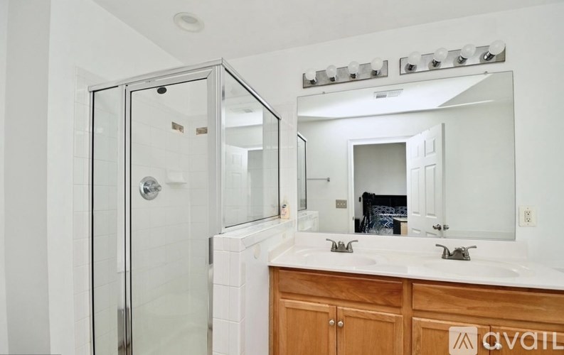 A bathroom with a white countertop and a wooden cabinet.