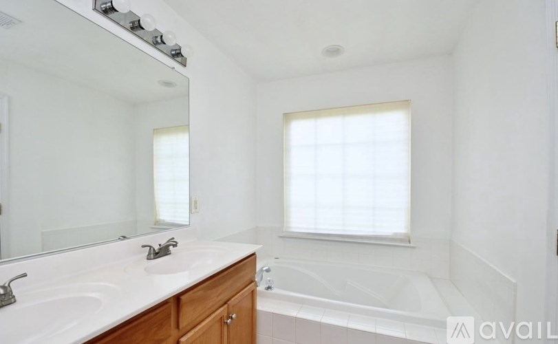 A bathroom with a white countertop and a window.