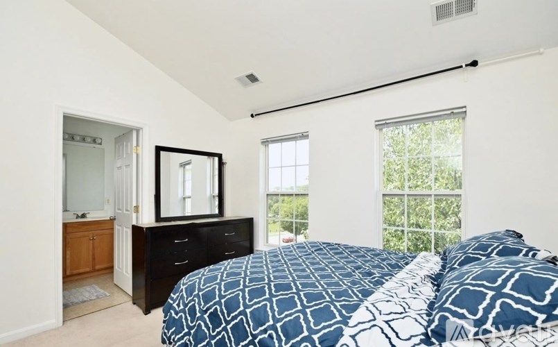 A bedroom with a bed, dresser, and mirror.