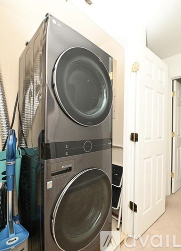 A washing machine and dryer stacked on top of each other in a small room.