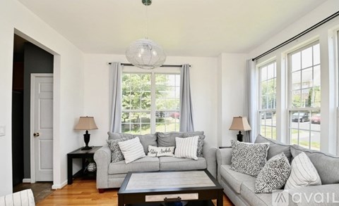 A living room with a grey couch and a white chair.