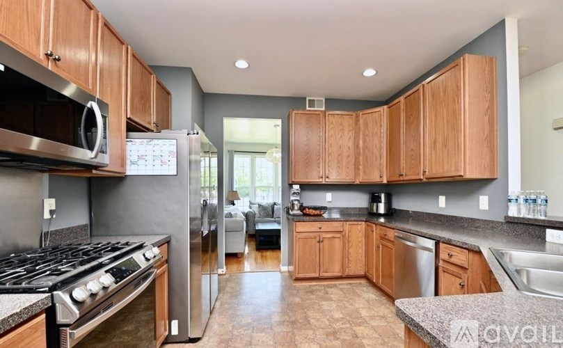 A kitchen with wooden cabinets and a stainless steel refrigerator.