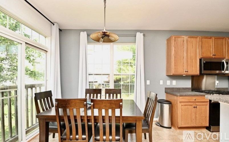 A kitchen with a table and chairs in front of a window.