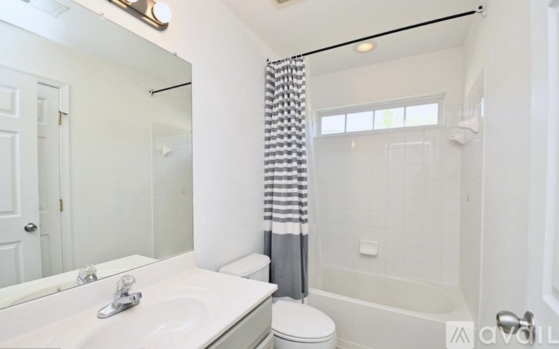 A bathroom with a white sink, toilet, and bathtub.
