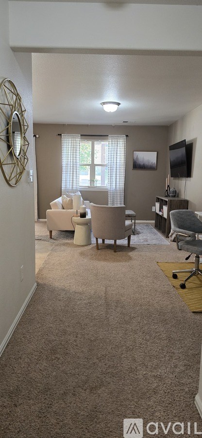 A living room with a couch, chair, and television.