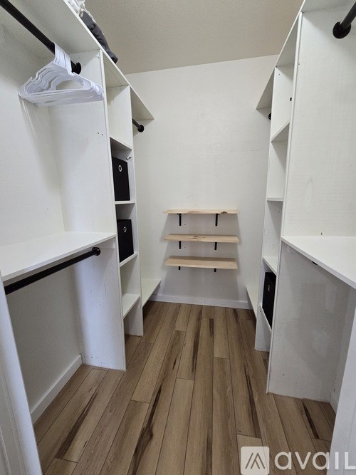 A white closet with a shelf and a hanger.