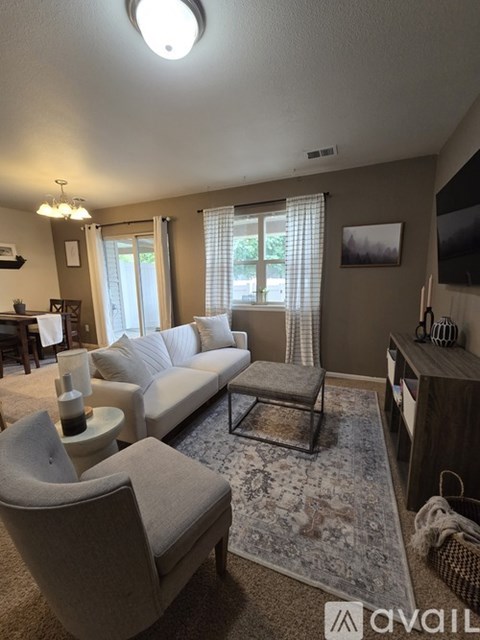 A living room with a grey sofa and a grey armchair.