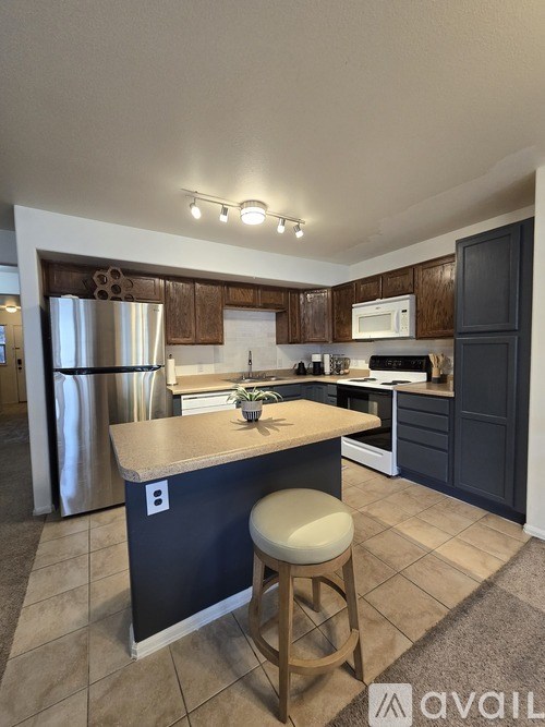 A kitchen with a bar stool in front of it.