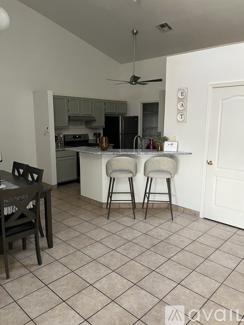 A kitchen with a dining table and chairs.