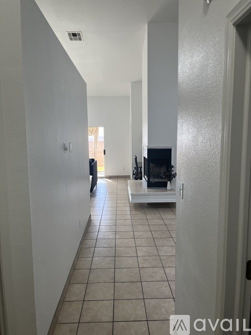 A hallway with a tiled floor and white walls.