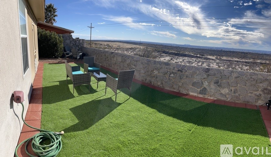 A patio with a table and chairs overlooking the beach.