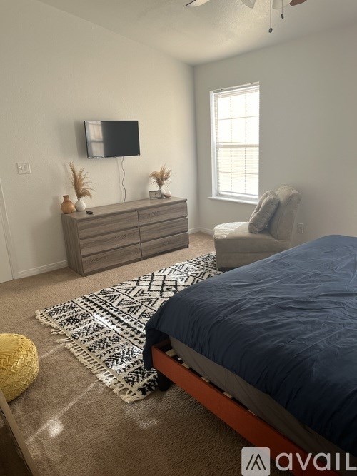 A bedroom with a bed, a dresser, and a window.
