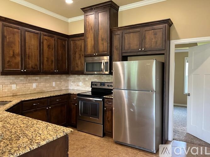 A kitchen with a granite counter top and stainless steel appliances.