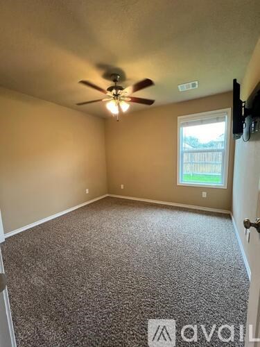 A room with a ceiling fan and carpeted floor.