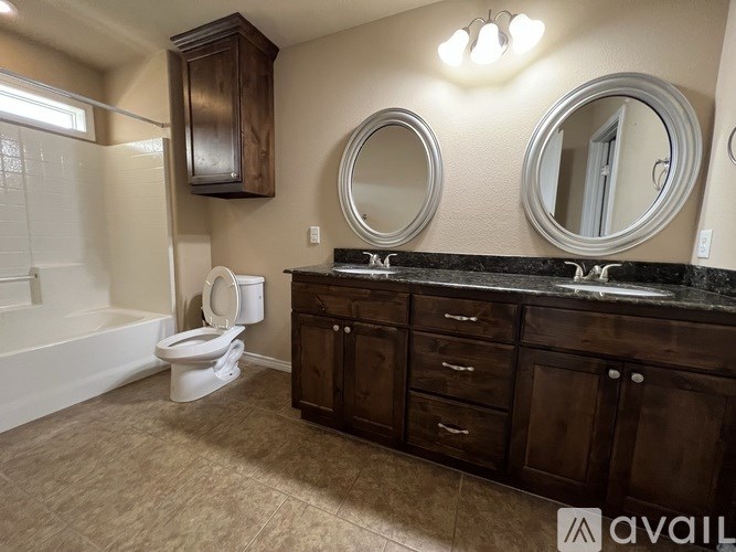 A bathroom with a toilet, sink, and mirror.