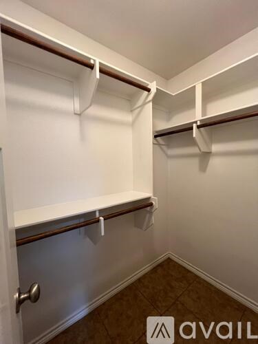 A white closet with a door and shelves.