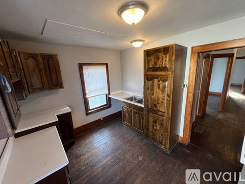 A room with wooden floors and a cabinet with a mirror on top.