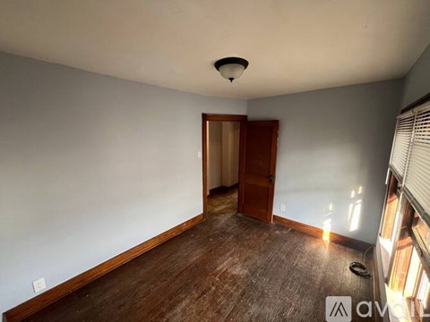 A room with a wooden floor and a ceiling fan.