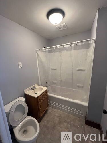 A bathroom with a toilet, sink, and bathtub.