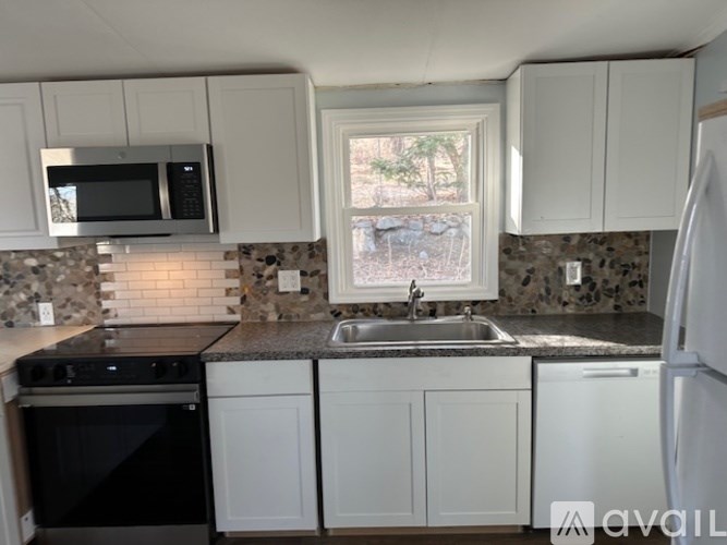 A kitchen with white cabinets and a black oven.