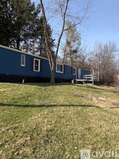 A blue house with a tree in front of it.
