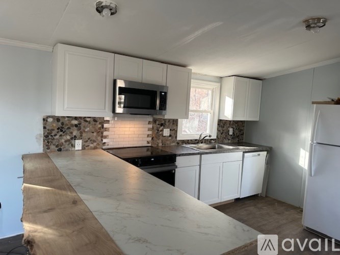 A kitchen with a marble countertop and white cabinets.
