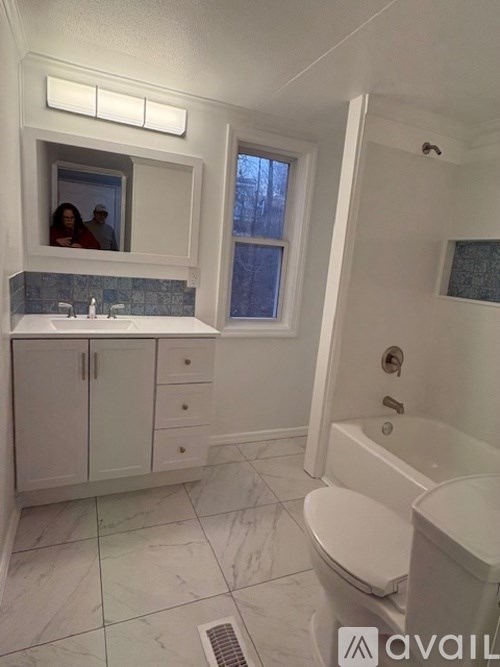 A bathroom with a toilet, sink, and bathtub.