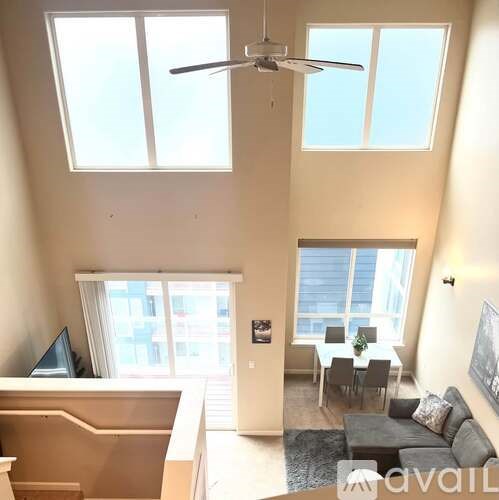 A living room with a couch, a dining table, and a television.