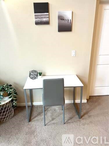 A white desk with a grey chair in a room.
