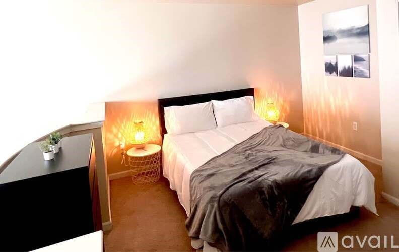 A bedroom with a bed, nightstand, and two lamps.