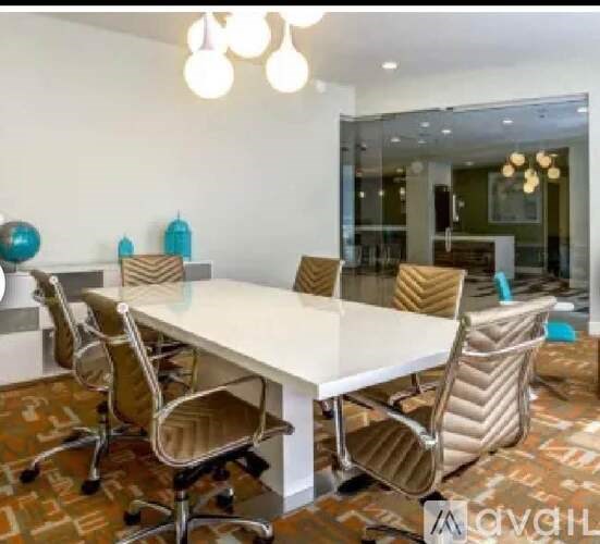 A conference room with a white table and chairs.