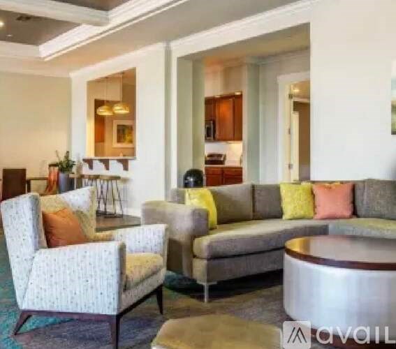 A living room with a grey couch and a patterned armchair.