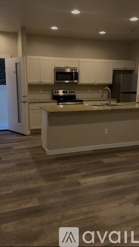 A kitchen with a wooden floor and white cabinets.