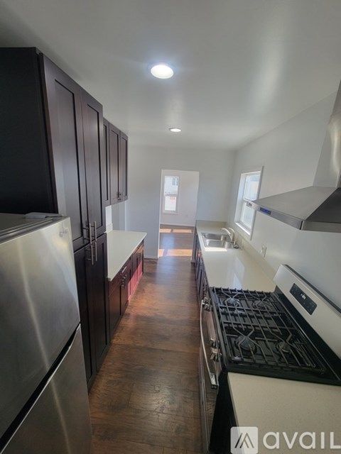A kitchen with dark wood cabinets and stainless steel appliances.