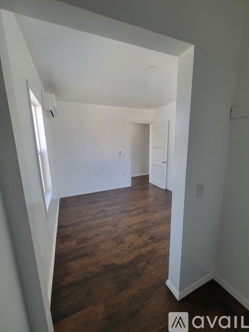 A room with white walls and wooden flooring.