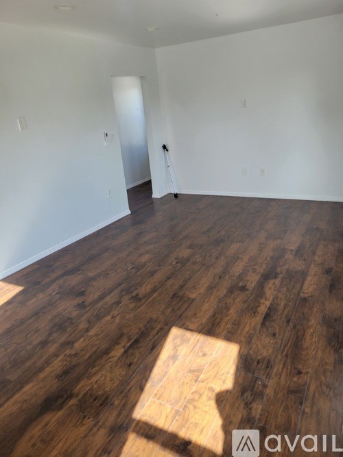 A room with wooden flooring and white walls.