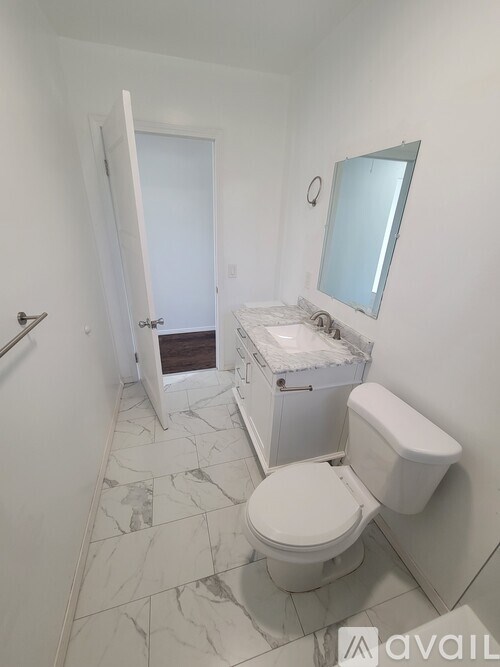 A white toilet in a bathroom with a marble floor.