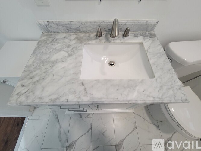 A marble bathroom sink with a silver faucet.