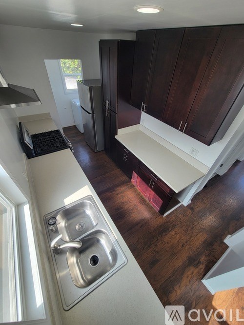 A kitchen with a sink and wooden cabinets.